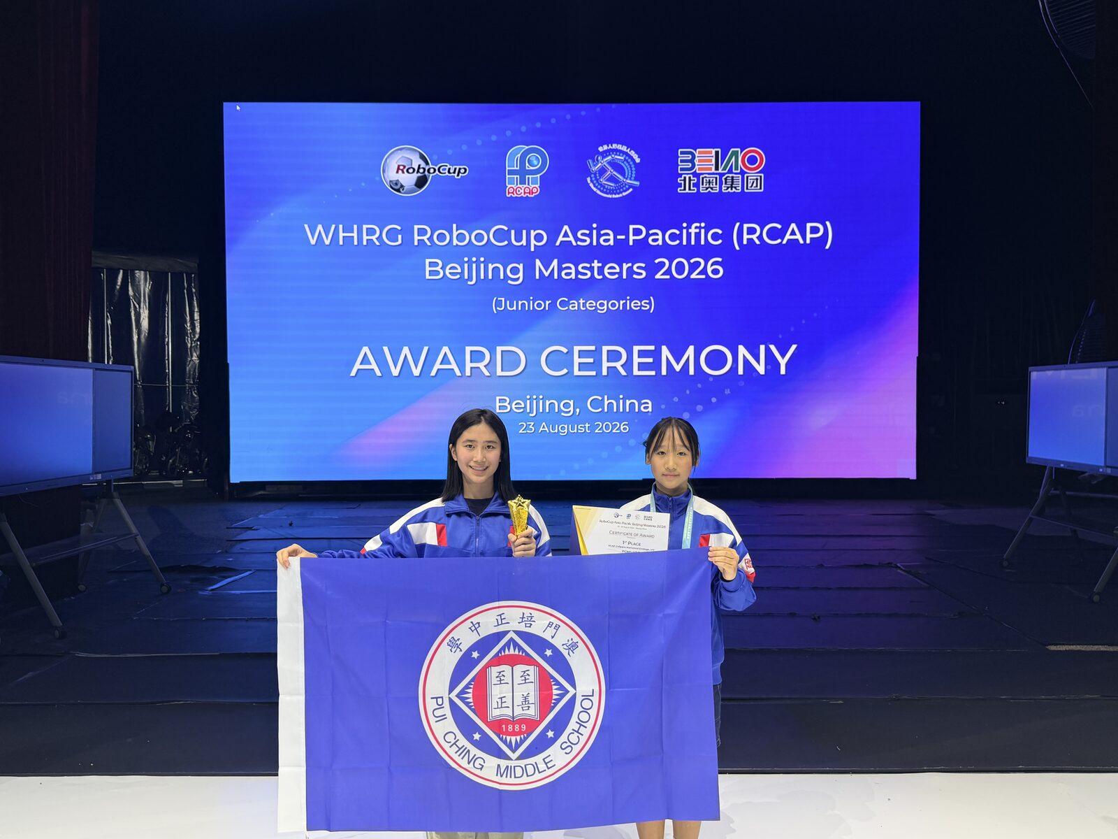 Receiving the award with the school flag at the ceremony