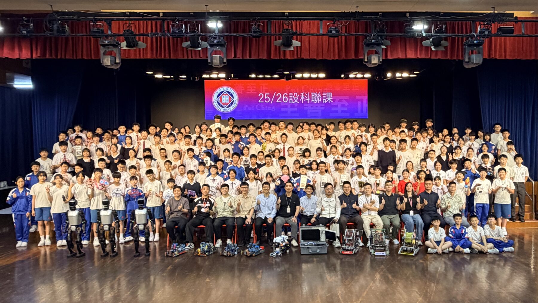 The full 2025–26 Design and Technology co-curricular group on stage with their competition robots