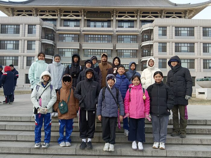 The group photographed on the steps of a Peking University building
