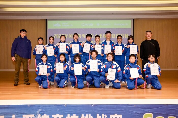Students on stage holding their certificates with their teachers