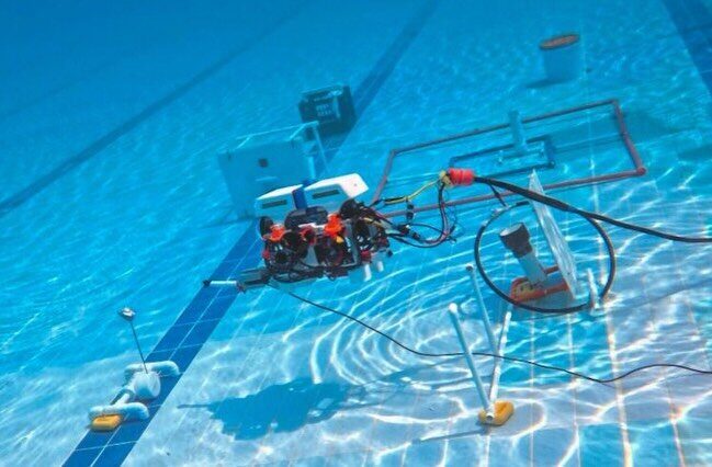 The ROV working a mission prop on the floor of the pool