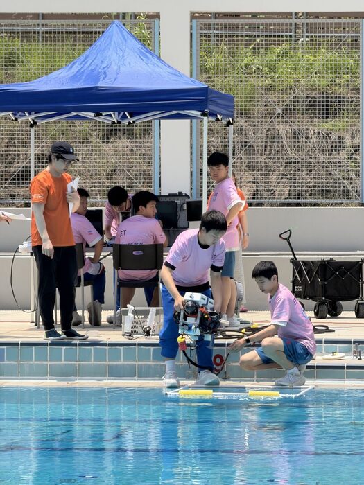 The team preparing the ROV under a canopy beside the outdoor pool