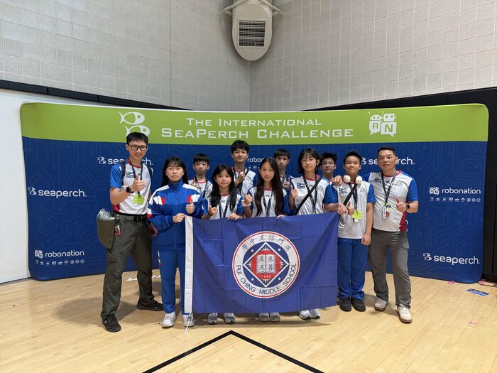 The team with the school flag at the International SeaPerch Challenge backdrop