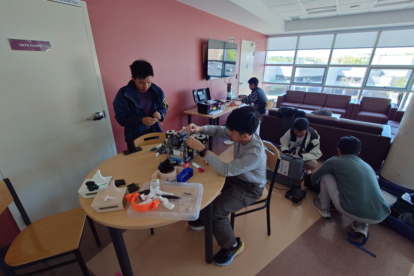 Team members working on the ROV at a table before a competition run