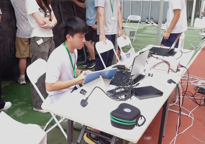 Students at the poolside control station with laptops during a run